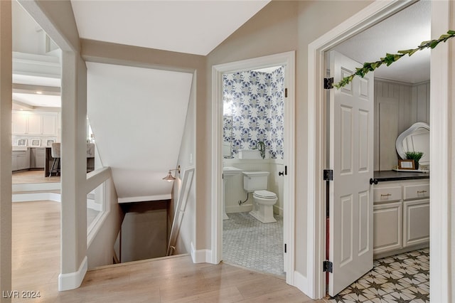 bathroom with wood-type flooring, toilet, and lofted ceiling