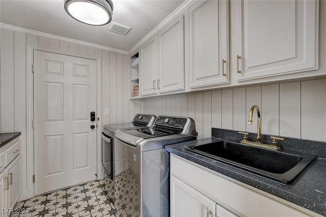 laundry area with washer and clothes dryer, sink, cabinets, and crown molding