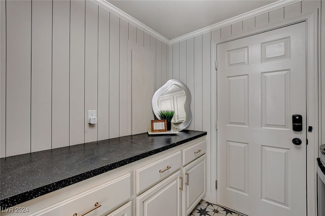 interior space featuring wooden walls and ornamental molding