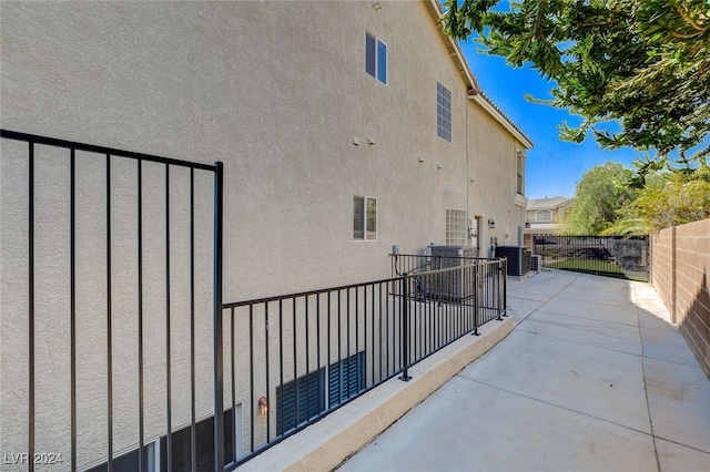 view of side of property with a patio and central AC unit