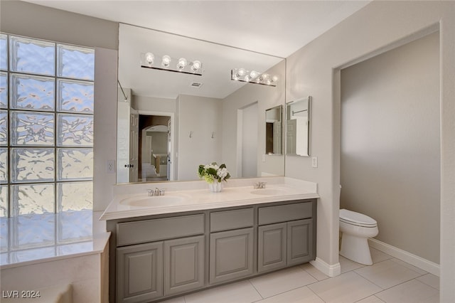 bathroom with tile patterned flooring, vanity, and toilet