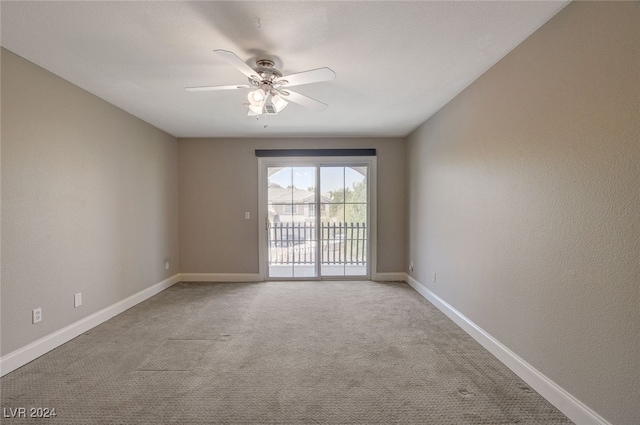 spare room featuring light colored carpet and ceiling fan