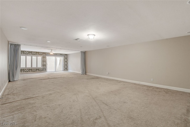 carpeted empty room with a textured ceiling