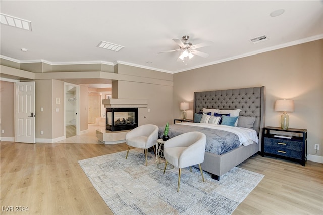 bedroom with light hardwood / wood-style flooring, ceiling fan, and crown molding