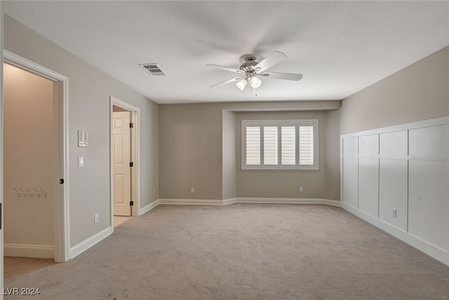 carpeted spare room with ceiling fan and a textured ceiling