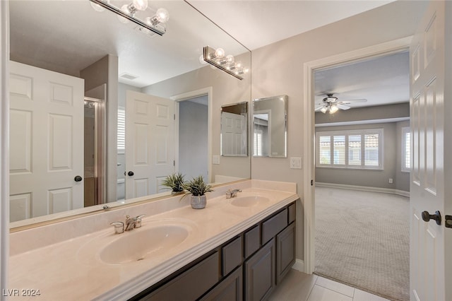 bathroom with tile patterned flooring, vanity, and ceiling fan with notable chandelier