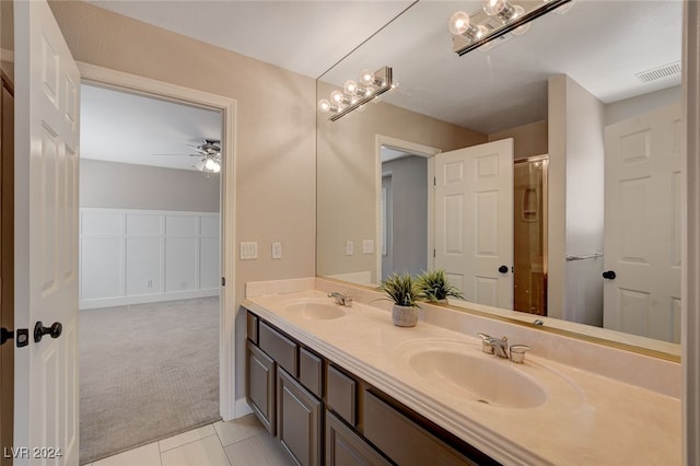 bathroom with tile patterned flooring, vanity, and ceiling fan with notable chandelier