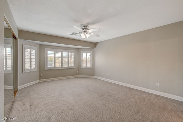 empty room with light colored carpet and ceiling fan