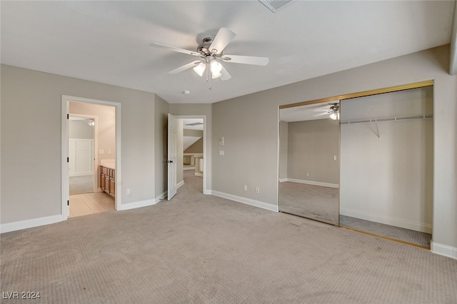 unfurnished bedroom with ceiling fan, ensuite bath, light carpet, and a closet