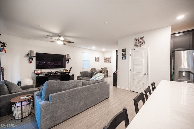 living room with light hardwood / wood-style flooring and ceiling fan