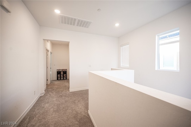 hallway featuring light colored carpet