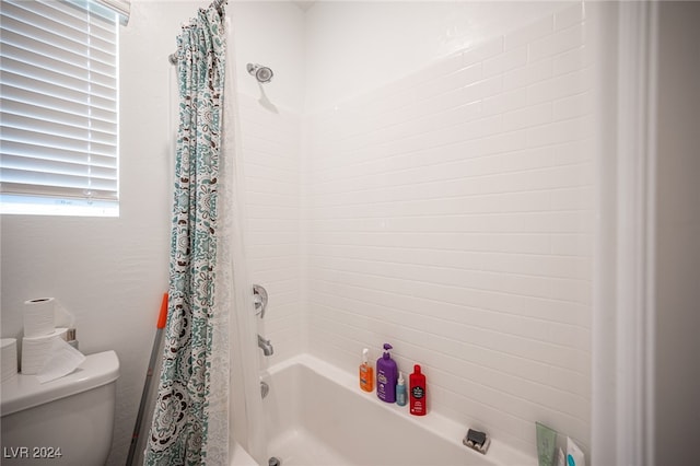 bathroom with shower / bath combo and toilet