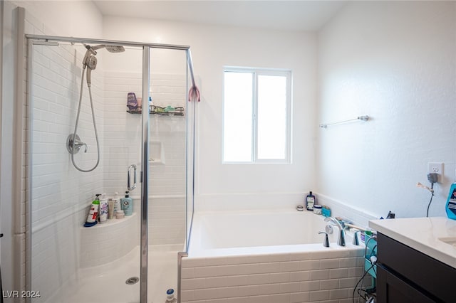 bathroom with vanity and independent shower and bath