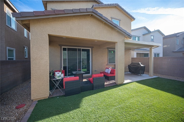 rear view of house with outdoor lounge area, a patio area, and a yard