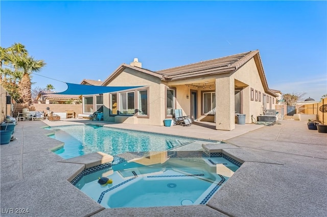 back of house featuring a patio and a pool with hot tub