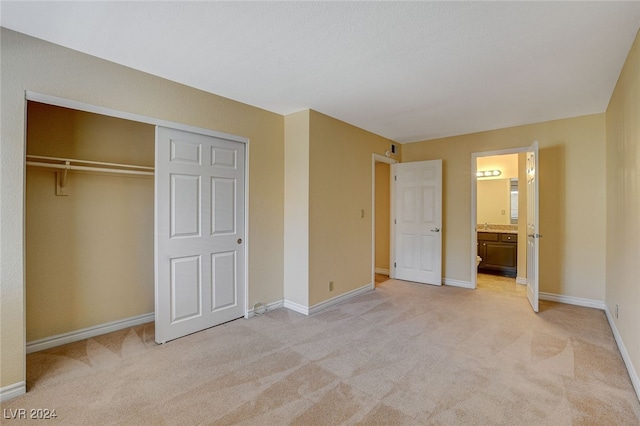 unfurnished bedroom with light carpet, baseboards, and a closet