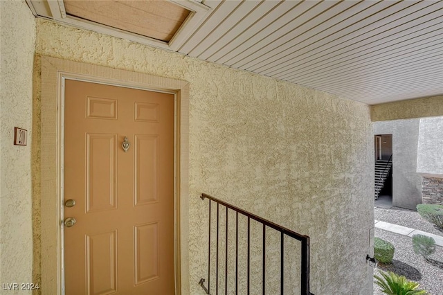 doorway to property featuring stucco siding