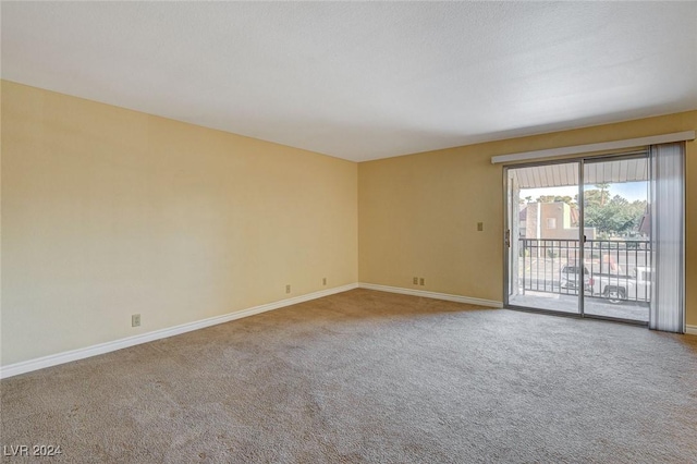 carpeted empty room featuring baseboards