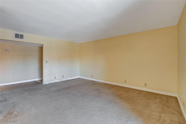 carpeted empty room featuring visible vents and baseboards