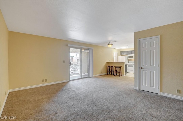 carpeted empty room featuring baseboards