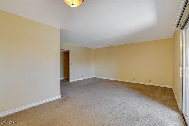 spare room featuring carpet floors and baseboards