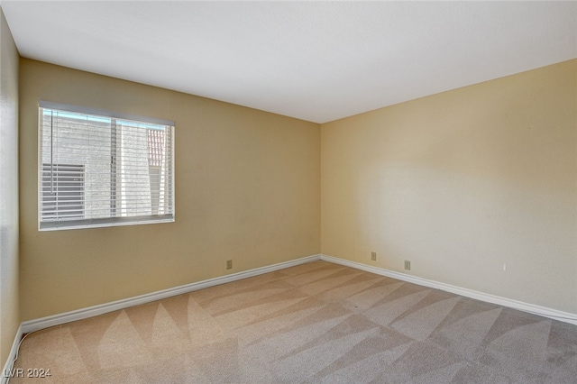 carpeted spare room with baseboards