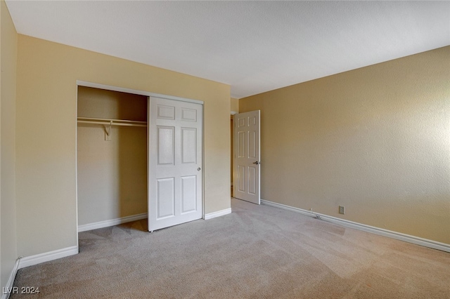 unfurnished bedroom featuring carpet floors, a closet, and baseboards