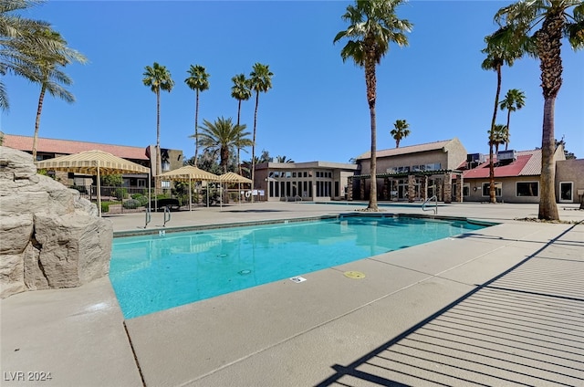 community pool with a patio and fence