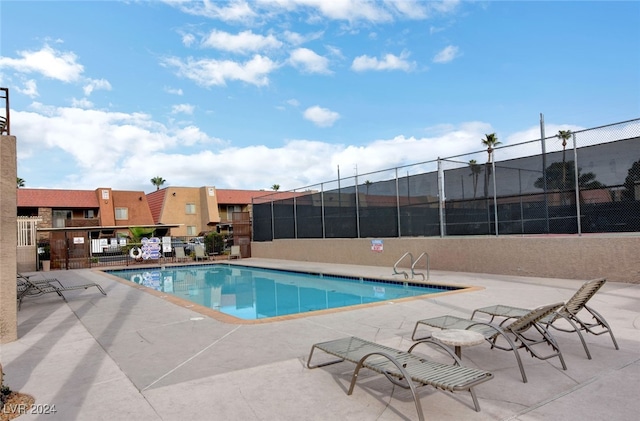 pool with a patio and fence