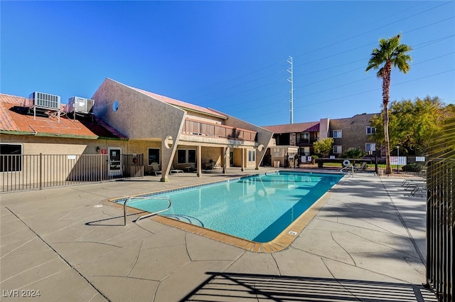 pool with central AC, a patio area, and fence