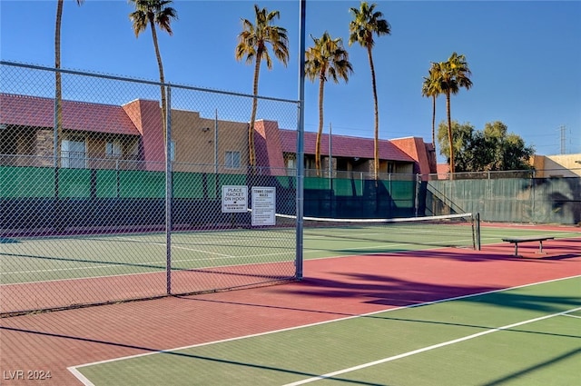 view of tennis court with community basketball court and fence