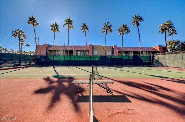 view of tennis court with community basketball court and fence