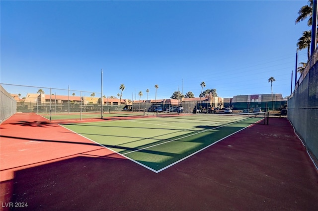 view of tennis court featuring community basketball court and fence