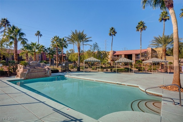 pool featuring fence and a patio