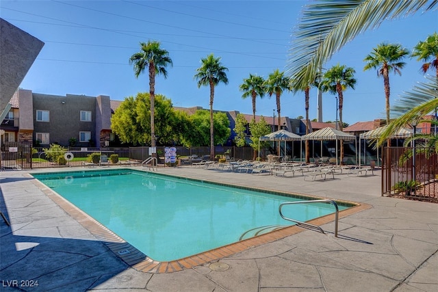 community pool with fence and a patio