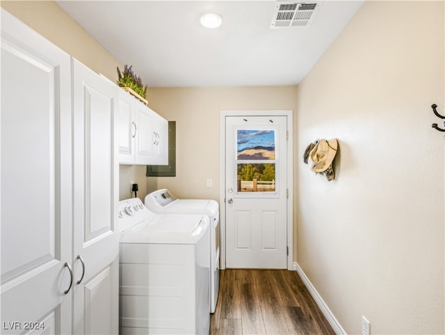 laundry area featuring cabinets, dark hardwood / wood-style flooring, and washing machine and clothes dryer