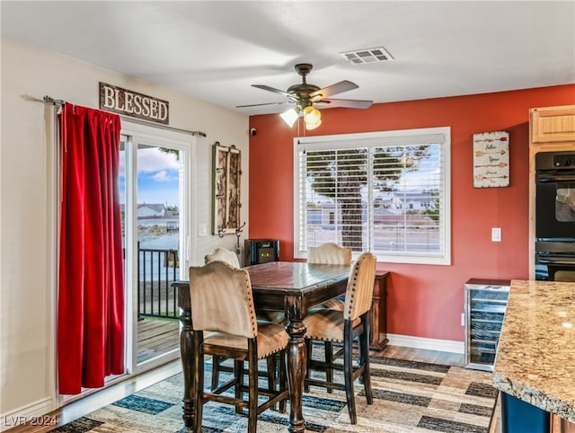 dining area featuring wine cooler, ceiling fan, and hardwood / wood-style floors