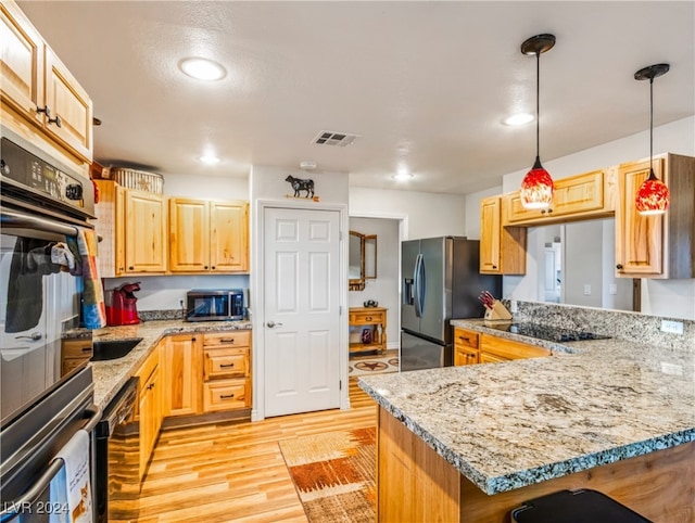 kitchen featuring pendant lighting, light stone countertops, light hardwood / wood-style flooring, and black appliances