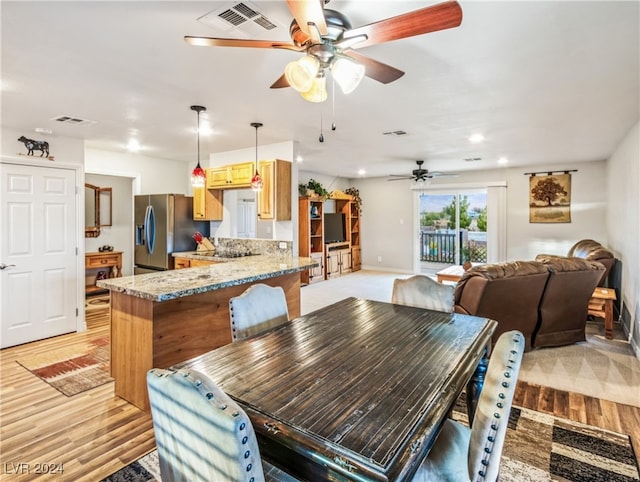 dining space featuring ceiling fan and light wood-type flooring