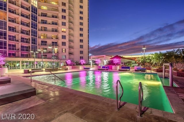 pool at dusk with a patio