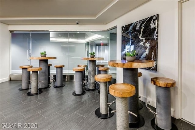 bar featuring a tray ceiling and dark hardwood / wood-style floors