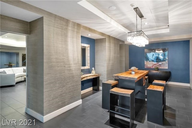 dining room with a tray ceiling and a notable chandelier