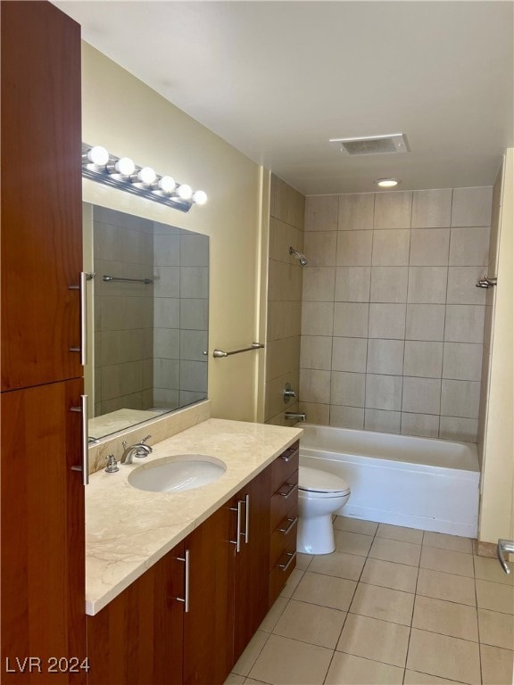 full bathroom featuring tile patterned floors, vanity, toilet, and tiled shower / bath