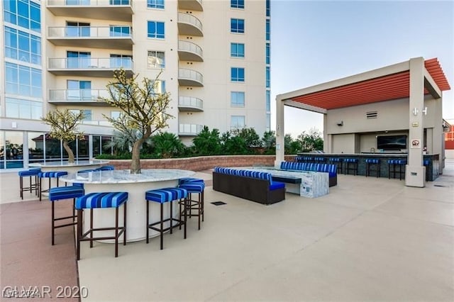 view of swimming pool featuring exterior bar and a patio