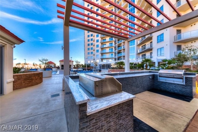 view of patio / terrace with an outdoor kitchen, area for grilling, and a pergola