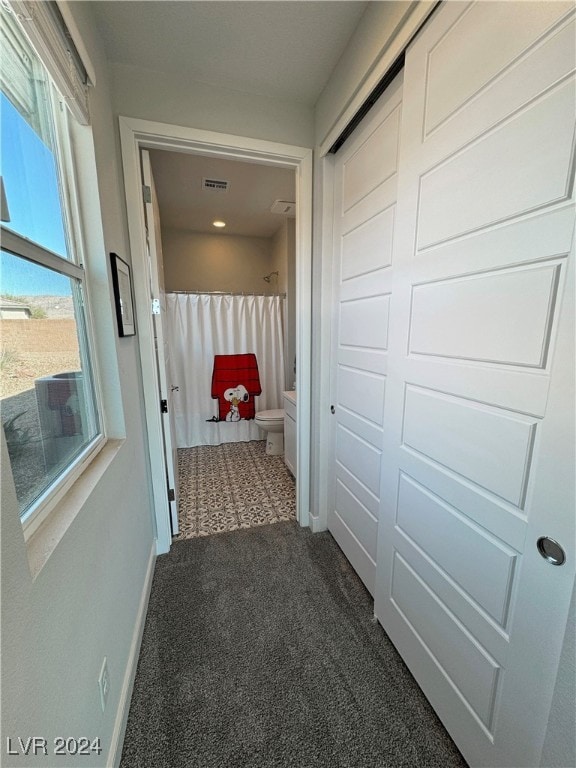 corridor with dark colored carpet