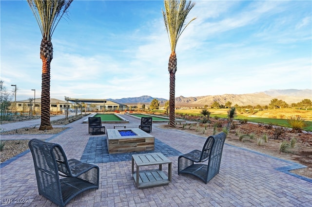 view of patio / terrace with a fire pit and a mountain view