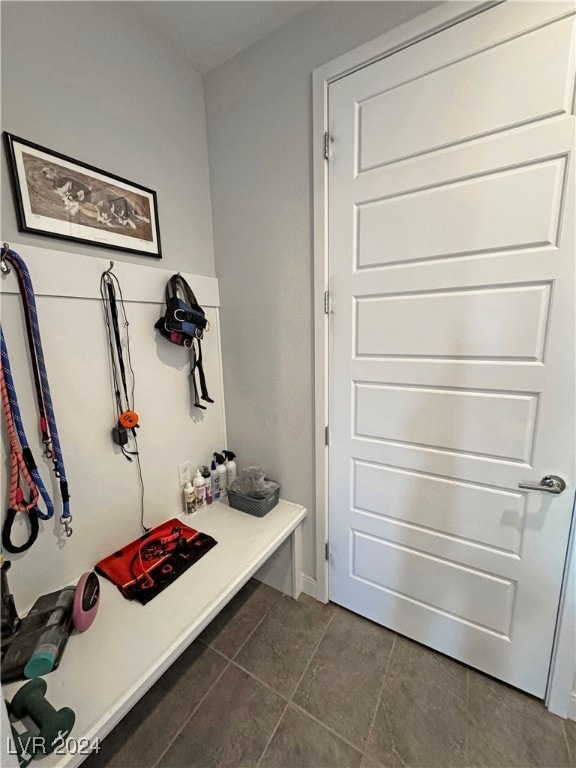 mudroom with dark tile patterned floors