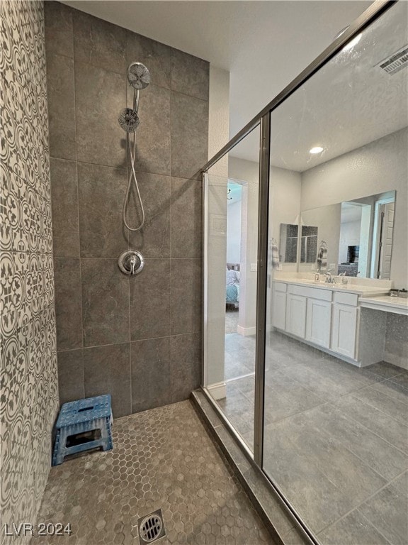 bathroom with a tile shower and vanity