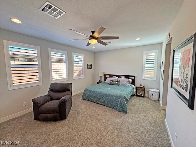 carpeted bedroom with ceiling fan and a textured ceiling